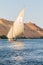 A felucca, a traditional wooden sailing boat, carrying tourists on the Nile river at Aswan