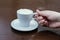 Femail hand holding coffee cup.