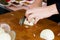 Femal hands shred white onion on a wooden cutting board