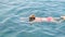 female 50-55-60 years old, wearing glasses, trains to crawl in the sea. Professional swimmer, swimming race. Front crawl