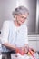 Female active pensioner is preparing strawberries