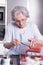 Female active pensioner is preparing strawberries