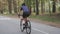 Female active sportive cyclist riding bicycle in the park. Cycling training. Bike ride. Slow motion