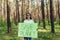 female activist standing in the woods with a poster save the planet, a volunteer struggles with deforestation