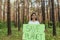 female activist standing in the woods with a poster save the planet, a volunteer struggles with deforestation