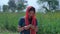 Female agricultural laborer happily counting her income standing in a field - Indian farmer