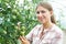 Female Agricultural Worker Checking Tomato Plants In Greenhouse