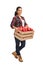 Female agricultural worker holding a crate full of apples