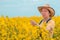 Female agronomist checking up on development of rapeseed crops in field, woman working on plantation