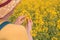 Female agronomist checking up on development of rapeseed crops in field, woman working on plantation