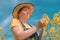 Female agronomist checking up on development of rapeseed crops in field, woman working on plantation