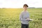 a female agronomist with a tablet checks the growth of a field with buckwheat flowers. the woman examines the field and