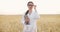 Female agronomist working in wheat field with digital tablet.Woman in white coat putting on glasses