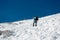 Female alpinist ascending a steep snowy slope.