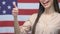 Female American patriot showing thumbs up gesture, right choice migration agency