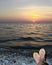 Female ankles against a sea landscape at sunset