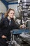 Female Apprentice Engineer Working On Drill In Factory