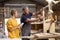 Female Apprentice Learning Skills From Mature Male Carpenter In Furniture Workshop