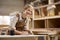 Female Apprentice Working As Carpenter In Furniture Workshop