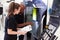 Female Apprentice Working With Engineer On CNC Machinery