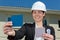 Female architect holding colour sample outside residential property