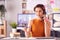 Female Architect In Office Working At Desk Making Online Purchase Using Credit Card On Mobile Phone