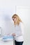 Female Architect Reading Documents At Desk