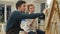 Female artist teaching young student to paint with watercolor