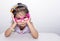 Female asian child girl posing wacky sad lonely pose while wearing some accessories like crown, necklace, pink eye glasses and