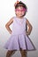 Female asian child girl posing wacky thinking pose while wearing some accessories like crown, necklace and wearing purple dress