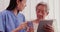 Female asian doctor pharmacist holding medicine pills explaining prescription to older woman patient.