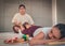 Female Asian getting leg massage by Thai masseur in Asian style massage spa