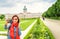 Female asian tourist in the baroque garden in front of the ancient architecture of royal Charlottenburg palace. Sightseeing