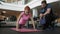 Female athlete conducts muscle training with personal fitness trainer.