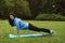 Female athlete doing exercises in the morning on a glade in the park