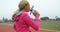 Female athlete drinking water on race track 4k