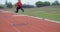 Female athlete jumping over hurdle on race track 4k