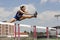 Female Athlete Jumping Over A Hurdles