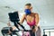 Female athlete with oxygen mask exercising with exercise bike in fitness studio