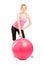 A female athlete posing next to a pilates ball