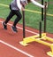 Female athlete pushing yellow sled on red track