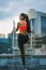 Female athlete standing on rooftop metal stairs