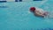 Female athlete swims with a butterfly style. A woman swimmer takes part in swimming competitions. She push off from the