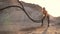 Female athlete training outdoors around the sand hills at sunset. Active physical activity workout. crossfit. The girl