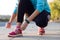 Female athlete tying laces for jogging.