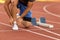 Female athlete tying laces for jogging. Woman jogging on a running track. running shoes. Fitness health.