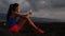 Female Athlete Using Smartphone While Sitting On Arid Landscape