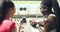 Female athletes laughing while using phone and browsing online together after exercise at stadium. Sporty friends and