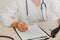 Female Ayurvedic doctor examines the patient and writes the patient`s history in the examination room of the hospital.