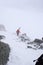 A female backcountry skier hiking up on a high alpine mountain in the Austrian Alps in winter in bad weather